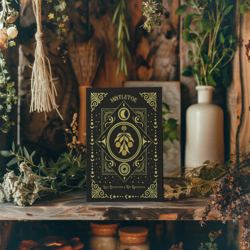 Elegant mistletoe-themed greeting card featuring gold detailing on a dark background with intricate celestial patterns. The text reads: 'Love, Protection & New Beginnings.' Inside message describes ancient Druid mistletoe traditions for blessings and prosperity in the New Year, with instructions for Winter Solstice use and symbolic burning for love and success throughout the year.
